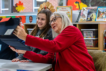 A grandmother and her grandchild using an iPad. Links to Gifts by Estate Note