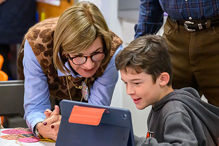 A grandmother helping her grandson on an iPad. A grandmother helping her grandson on an iPad.