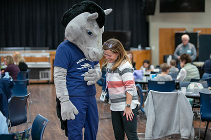 A woman with The Mount Vernon School mascot. Links to Beneficiary Designations